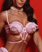 Dettaglio reggiseno rosa in tulle con perle decorative, indossato da modella, scollo profondo
